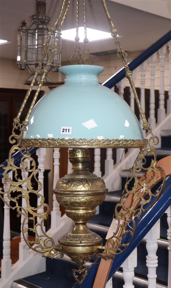 A brass hanging light and glass shade